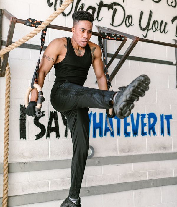 Man performing a controlled strength exercise in a dark, focused environment.